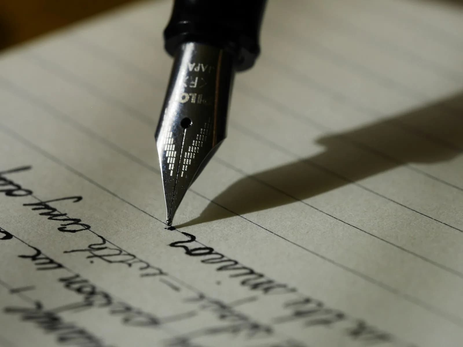 Hand setzt mit Füllfeder eine Unterschrift unter ein Dokument
