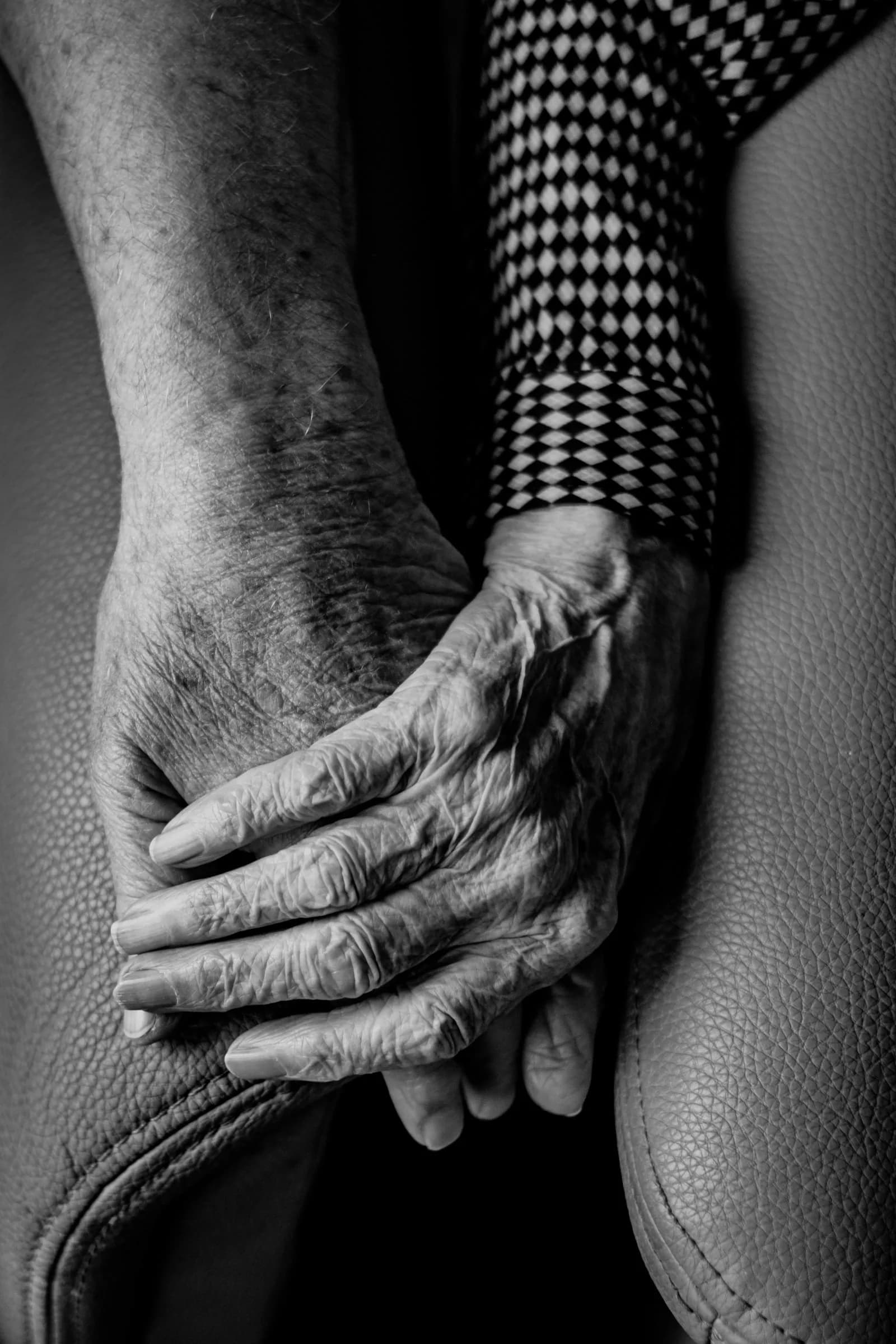 Junge Hand hält ältere Hand — Symbol für Vorsorge und Vertrauen